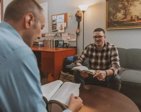 Two men discuss the Bible, exploring why God sent Jesus to save humanity.