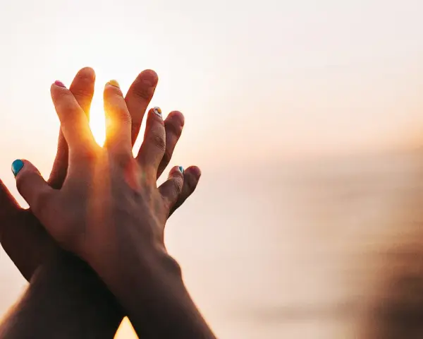 Two hands clasped at sunset, a symbol of purity and what is chastity: a deep, respectful connection.