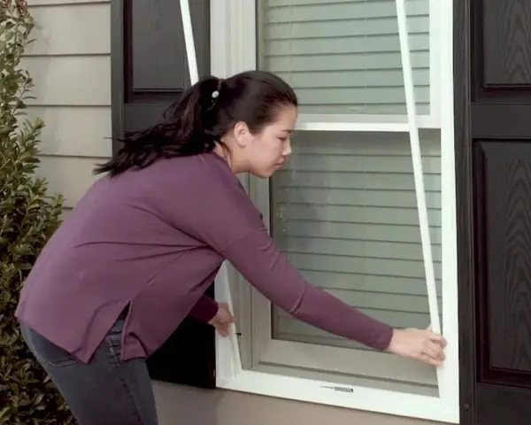 Woman demonstrates how to replace screen door mesh on a window.