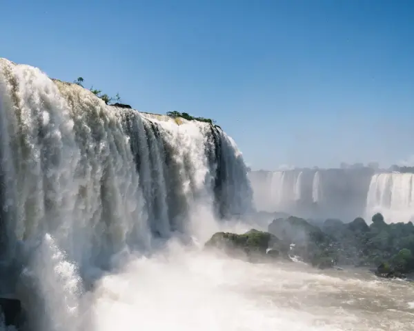 Potężne wodospady Iguazú w Argentynie, kaskady wody spadające z klifów, otoczone zielenią i spowite mgiełką.