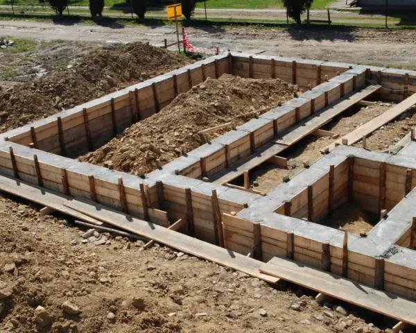 Zbrojenie ławy fundamentowej 40x60 w drewnianym szalunku, gotowe do zalania betonem.