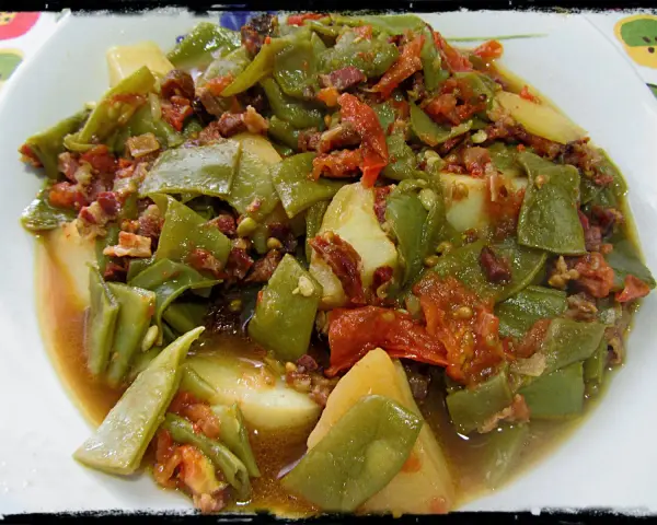 Judías verdes tiernas con patatas y trocitos de jamón, cocinadas en olla express. Un plato casero y delicioso.