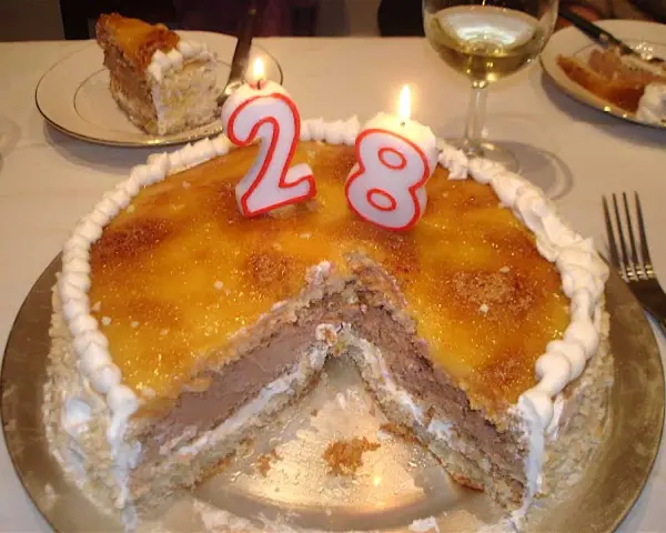 Tarta San Marcos con velas de cumpleaños número 28, lista para celebrar.