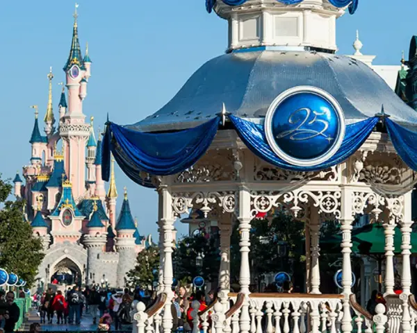 El castillo rosa de Disneyland Paris se alza majestuoso, con un quiosco decorado para celebrar el 25 aniversario.