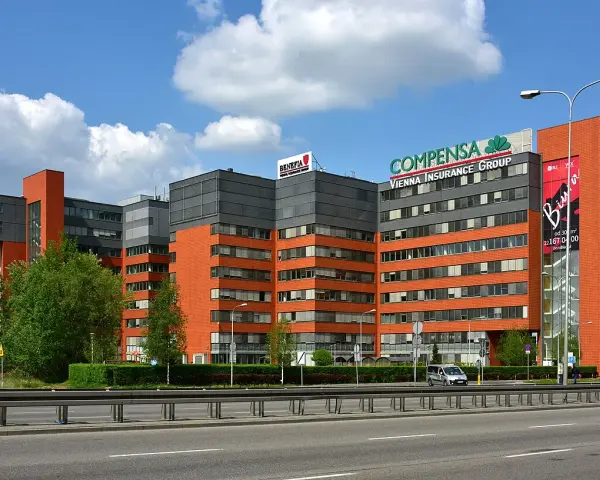 Nowoczesne budynki biurowe z logo Compensa Vienna Insurance Group. Opinie o vienna life są tu pewnie pozytywne.