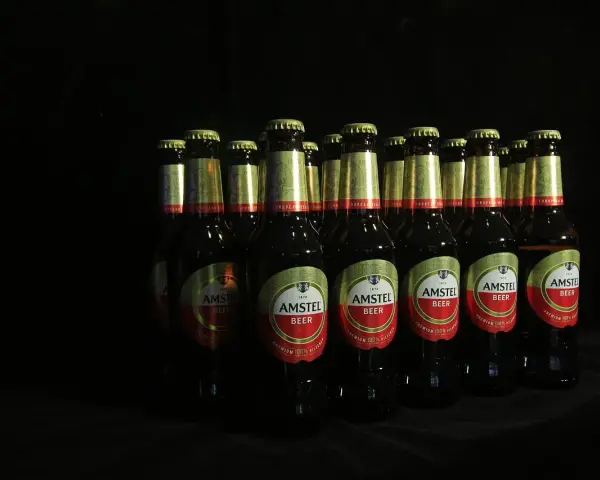 Rząd butelek piwa Amstel. Lepiej 2 drinki czy 2 piwa? Wybór należy do Ciebie, ale te piwa wyglądają kusząco.