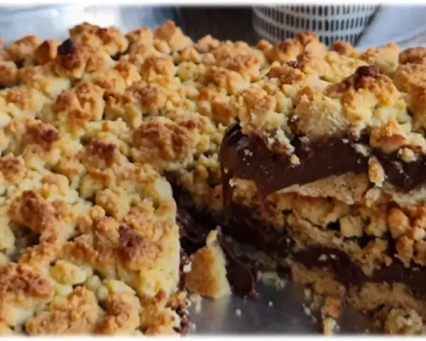 Sbriciolata alla Nutella golosa, con strati di crema al cioccolato e croccante frolla sbriciolata. Un dolce irresistibile per ogni occasione.