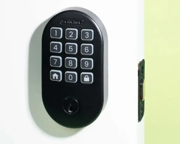 Black Schlage keypad lock on a white door, showing numbers and icons. Learn how to change door lock code for enhanced security.