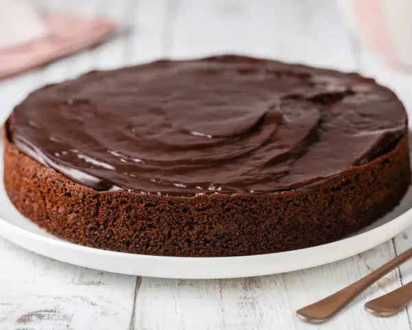 Torta al cioccolato soffice, ricoperta da una glassa lucida. Perfetta per chi ama il cioccolato, questa torta con cioccolato avanzato è un vero piacere.