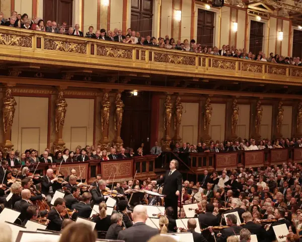 Un director dirige una orquesta sinfónica ante un público entusiasta, interpretando obras de Beethoven en un teatro majestuoso.