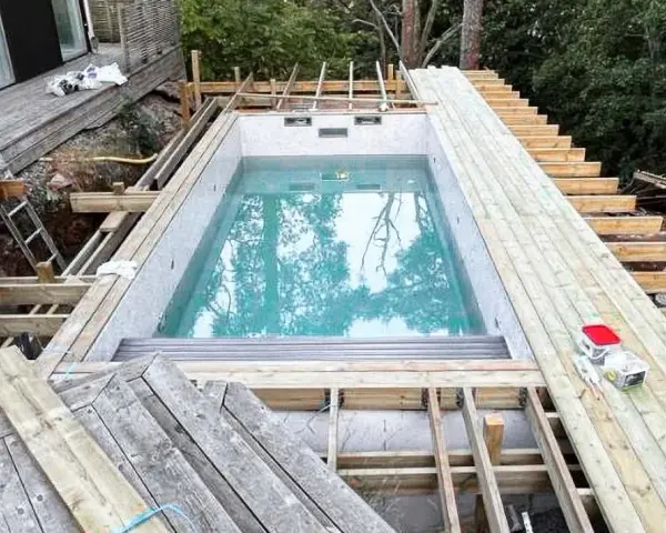 Byggnation av pool med tillhörande trädäck och trappa. Ger bastu inspiration för framtida projekt.