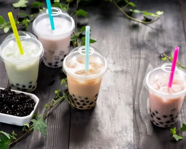 Różne rodzaje herbaty do bubble tea: zielona, mleczna, brązowa i różowa, z tapioką.