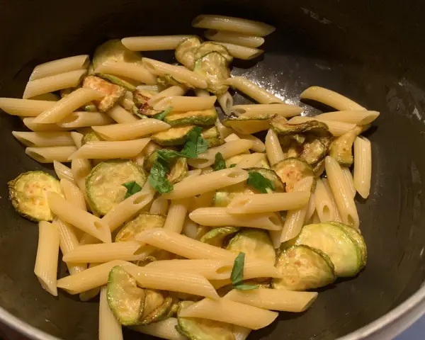 Penne con zucchine saltate e basilico fresco, un classico piatto di pasta e zucchine alla siciliana, pronto per essere gustato.