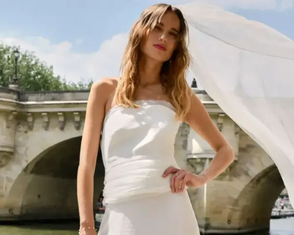 Robe de mariée aérienne signée Rime Arodaky, créatrice, sur un pont parisien.
