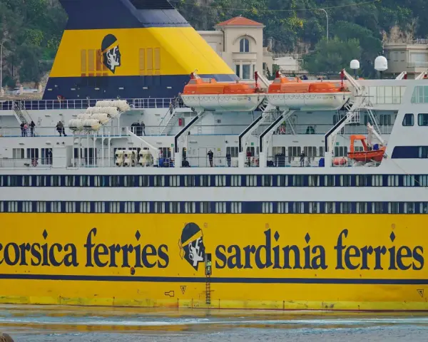Żółty prom "Corsica Ferries Sardinia Ferries" z ludźmi na pokładzie, gotowy do podróży motocyklem na Sardynię.