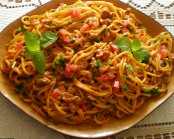 Spaghetti bolognese – prosty przepis. Aromatyczny sos mięsny z pomidorami i bazylią na złocistym makaronie.