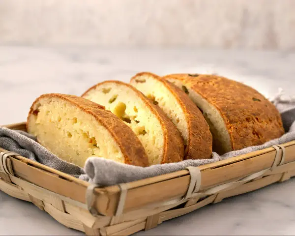 Pokrojony chleb keto przepis w koszyku. Ma złocistą skórkę i jasny, puszysty środek.