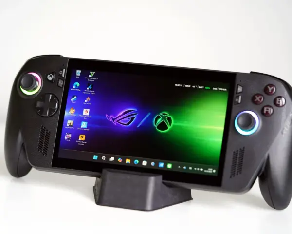 Przenośna konsola gamingowa z kontrolerami, ekranem wyświetlającym pulpit z ikonami gier i logo Xbox. To idealne urządzenie dla graczy, którzy chcą zabrać swoje ulubione tytuły wszędzie, nawet te z Xbox Game Pass.