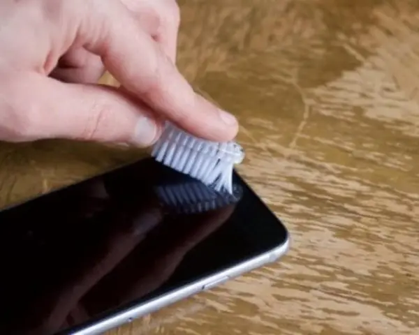 Delikatnie szczotkuj głośnik iPhone'a, aby usunąć kurz i brud. Prosty sposób, jak wyczyścić głośnik iPhone.