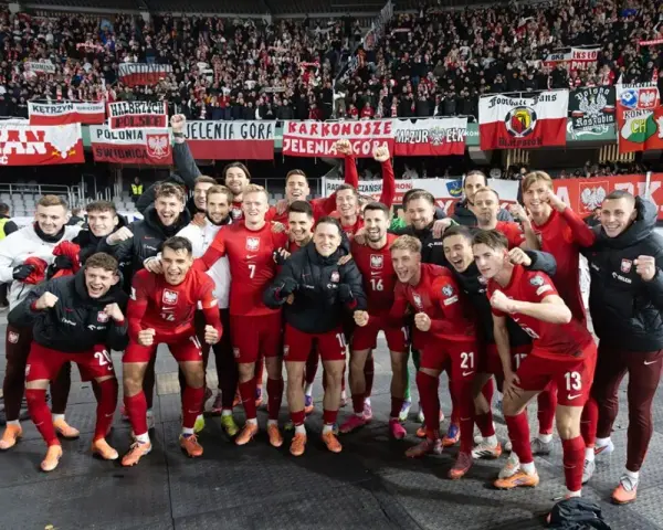 Radosna me grupa polska w czerwonych strojach świętuje z kibicami.
