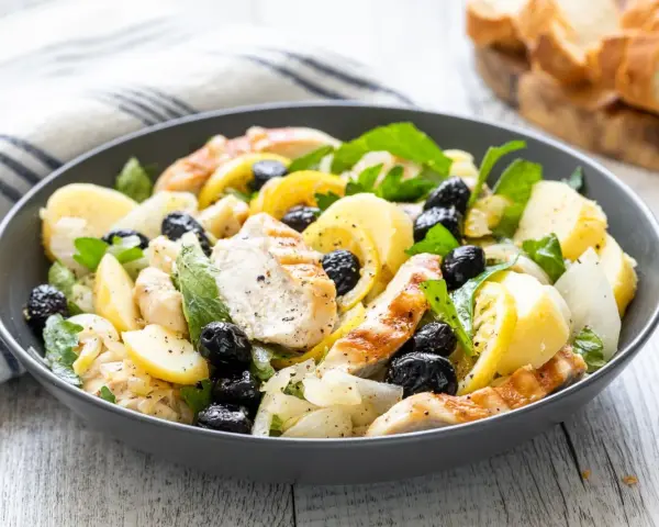 Insalata di pollo sfiziosa con patate, olive nere e limone, un piatto fresco e saporito.