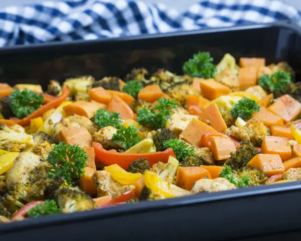Ofenblech mit Hähnchen, Brokkoli, Süßkartoffeln und Paprika, garniert mit Petersilie. Perfekt für histaminarme Rezepte.