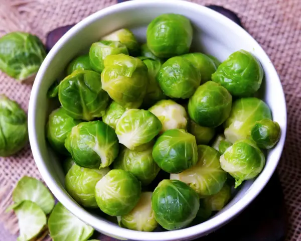 Frischer Rosenkohl in einer Schüssel. Die Frage "wie lange muss rosenkohl kochen" beschäftigt viele Hobbyköche.