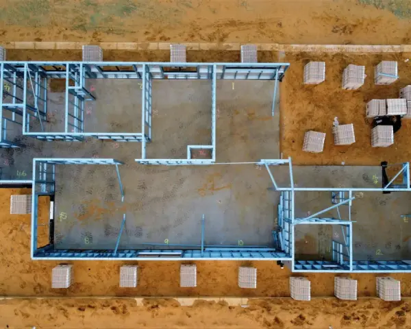 Estructura metálica de una casa en construcción. Se aprecian materiales apilados, listos para el montaje. El precio de hacer un sótano puede variar.