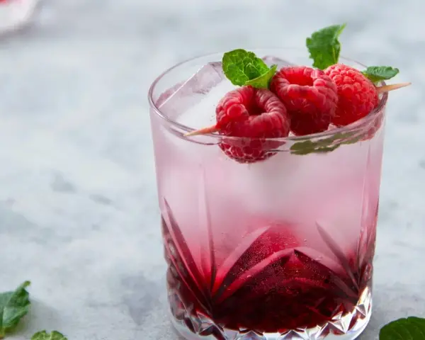 Orzeźwiający drink Wściekły Pies z malinami i miętą, idealny na letnie popołudnie.