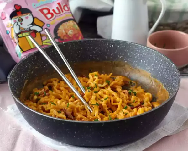 Pikantny buldak carbonara w patelni, gotowy do jedzenia.
