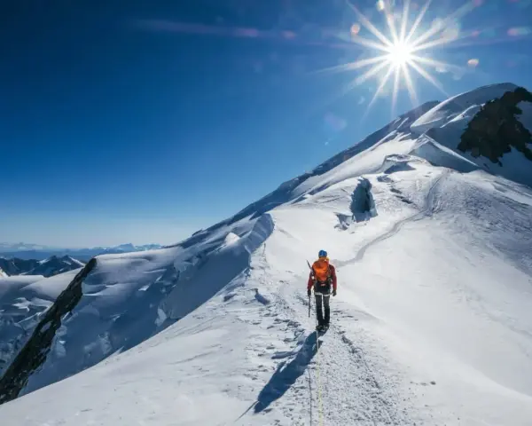 Bergsteiger auf dem Weg zum Gipfel des Mont Blanc. Die Sonne strahlt vom klaren blauen Himmel.
