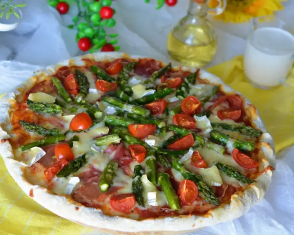 Pyszna pizza ze szparagami, pomidorkami i serem. Idealna na wiosenny obiad.