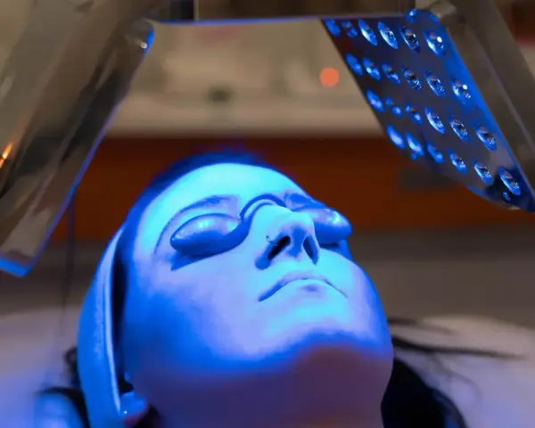 Woman receiving blue light therapy, exploring the blue light benefits for skin.