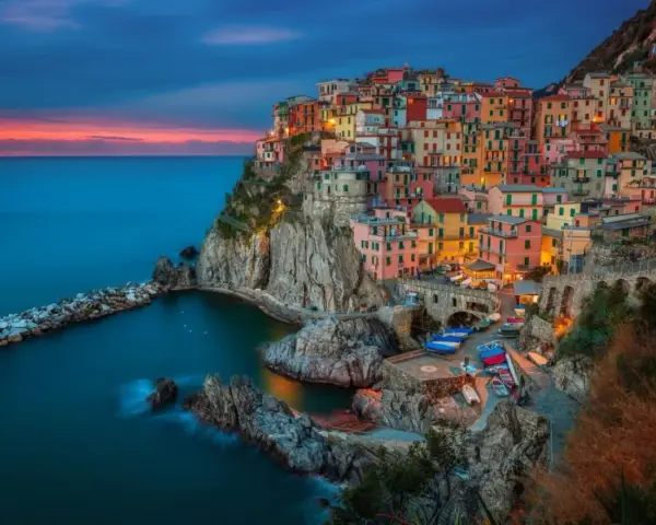 Kolorowe domy Cinque Terre, Włochy, w blasku zachodzącego słońca. Idealne miejsce na wycieczkę do Włoch.