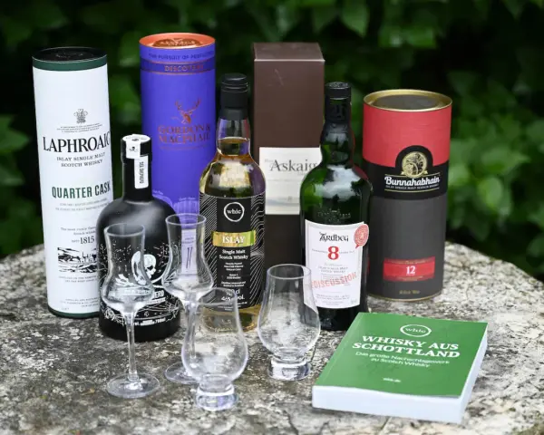 Laphroaig Aussprache: Eine Auswahl schottischer Single Malts, darunter Laphroaig Quarter Cask, Ardbeg 8, Bunnahabhain 12 und mehr, bereit für eine Verkostung.