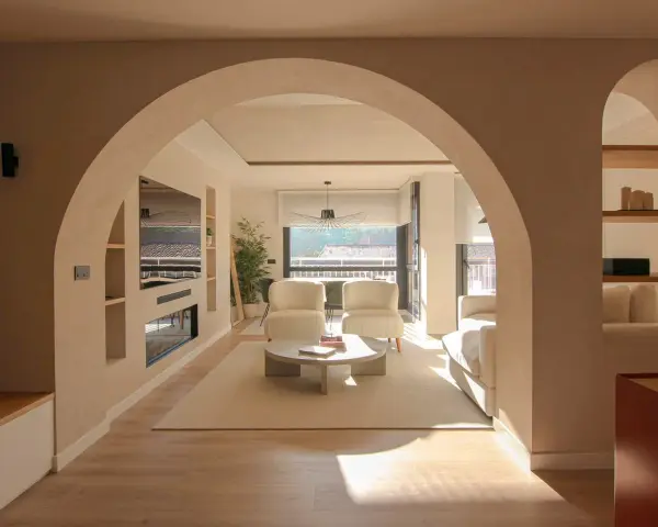 Amplio salón con entrada recibidor integrado. Dos sillones blancos, mesa de centro y sofá invitan a la relajación.