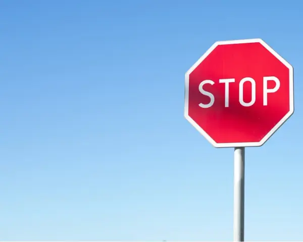 Czerwony znak STOP na tle błękitnego nieba. Uważaj, by nie dostać mandatu za stop!