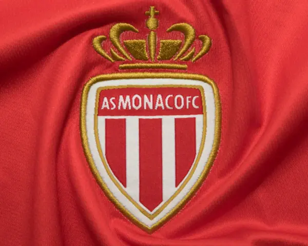 Herb AS Monaco FC na czerwonym tle. Duma z osiągnięć i rankingi klubu.