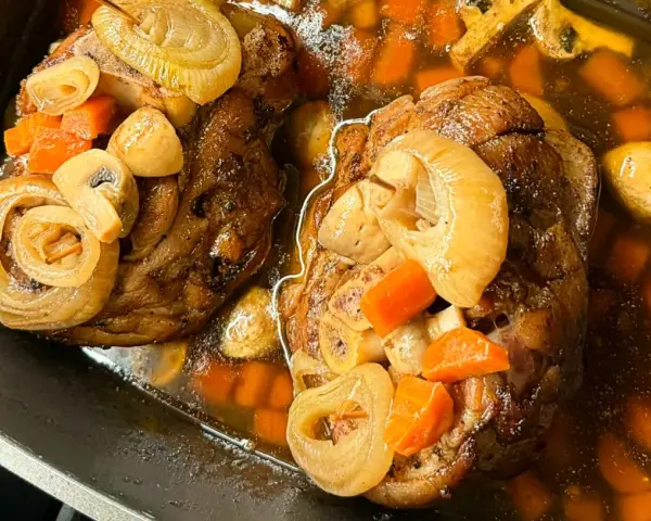 Dwie soczyste golonki, gotowane i pieczone, w aromatycznym sosie z marchewką, cebulą i grzybami. Najlepsza golonka gotowana i pieczona.