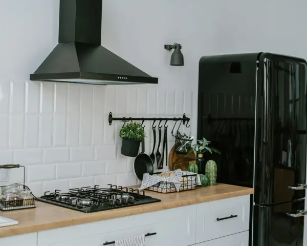 A clean vent hood filter is crucial for kitchen safety and efficiency. This image shows a modern kitchen with a black vent hood over a gas stove.