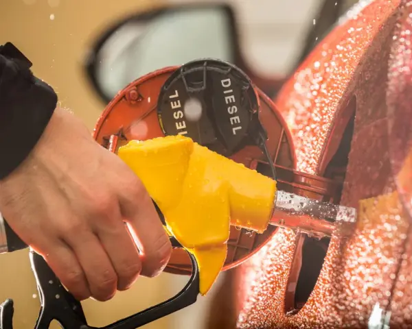 Mano che inserisce la pompa diesel. Cosa succede se metti benzina nel diesel? Dopo quanti km si notano i danni?