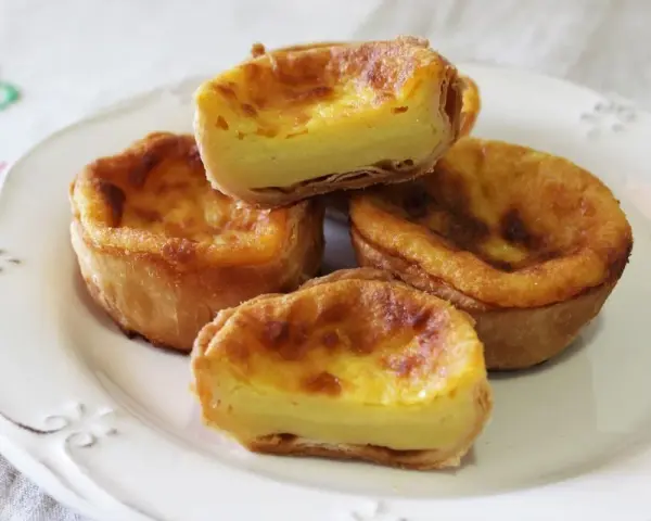 Pastel de arroz con relleno cremoso y masa hojaldrada, servido en un plato blanco.