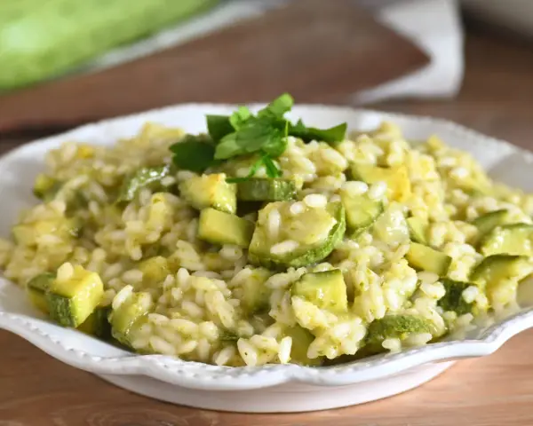 Un cremoso risotto con zucchine, guarnito con prezzemolo fresco, pronto per essere gustato.