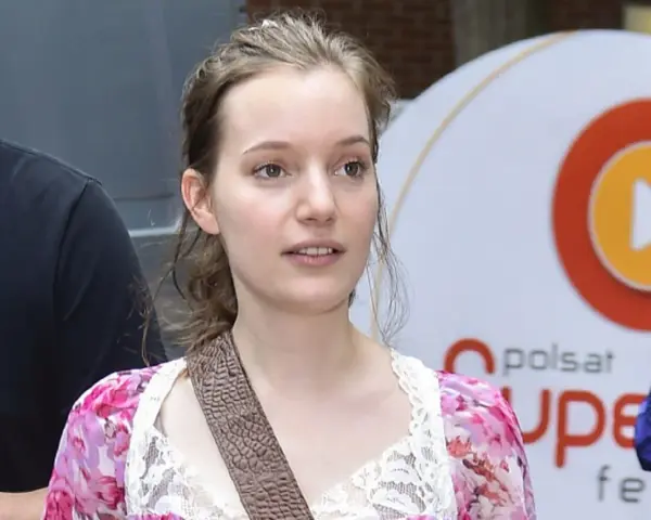 Zuzanna Jurczak, The Voice of Poland, w kwiecistej sukience z koronką, z brązowym paskiem przez ramię.