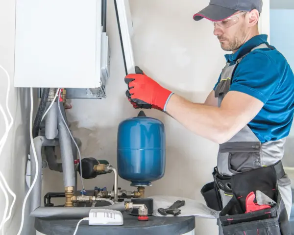 Instalator sprawdza podzespoły kotła gazowego. Zastanawiasz się, ile kosztuje piec gazowy?
