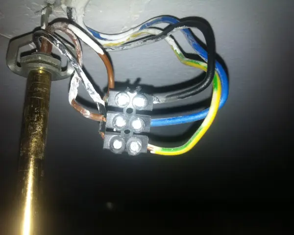 Widok z bliska na połączenie przewodów elektrycznych żyrandola z kostką.
