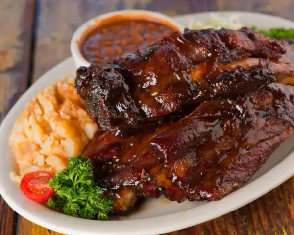 Soczyste żeberka w sosie BBQ, podane z puree ziemniaczanym i fasolką. Idealna marynata do żeberek sprawia, że mięso jest kruche i aromatyczne.