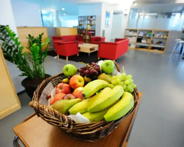 Koszyk pełen jabłek, bananów, gruszek i winogron. Idealny na owocowe czwartki w biurze.