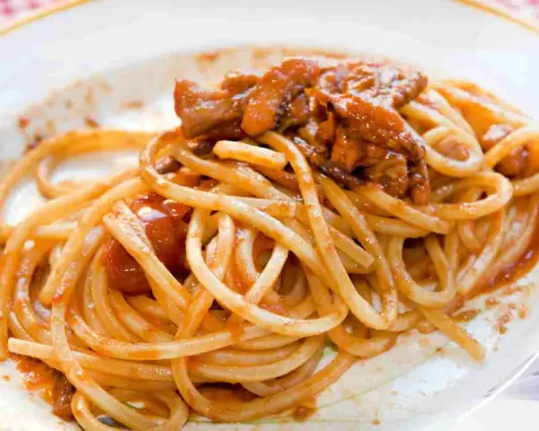 Spaghetti alla chitarra con sugo di carne, un piatto ricco e saporito, pronto per essere gustato.
