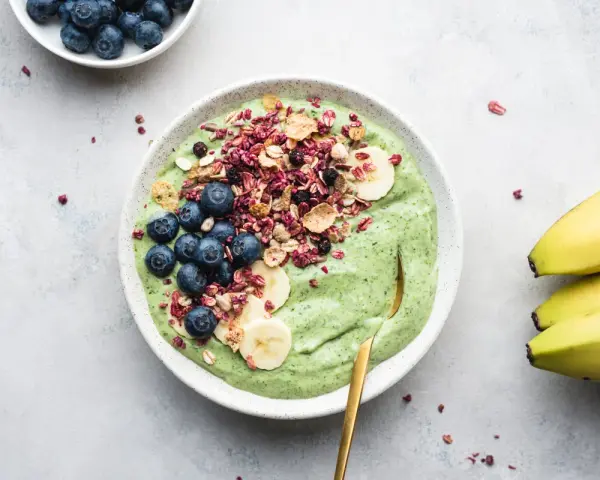 Grön smoothiebowl med blåbär, banan och granola. Ett perfekt proteinrikt mellanmål för en energifylld dag.